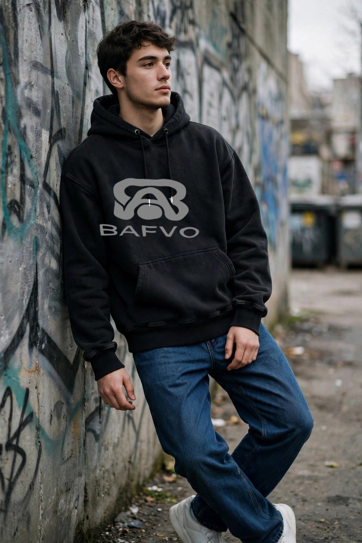 Man wearing a black BAFVO heavyweight hoodie in a Toronto graffiti alley