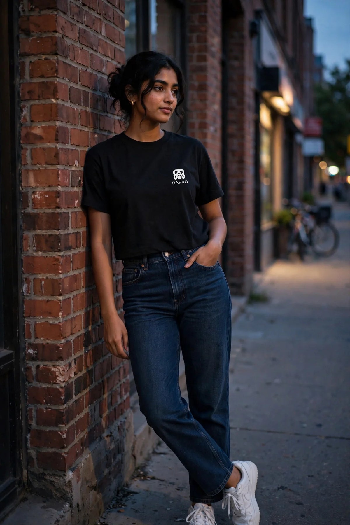 Model wearing a black BAFVO boxy fit tee on a Toronto street at dusk, showing the relaxed square silhouette