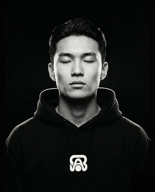 Portrait studio en noir et blanc d'un homme souriant portant un sweat à capuche BAFVO noir